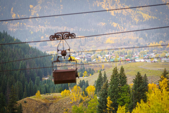 An old ore cart suspended on a cable overlooking Silverton.